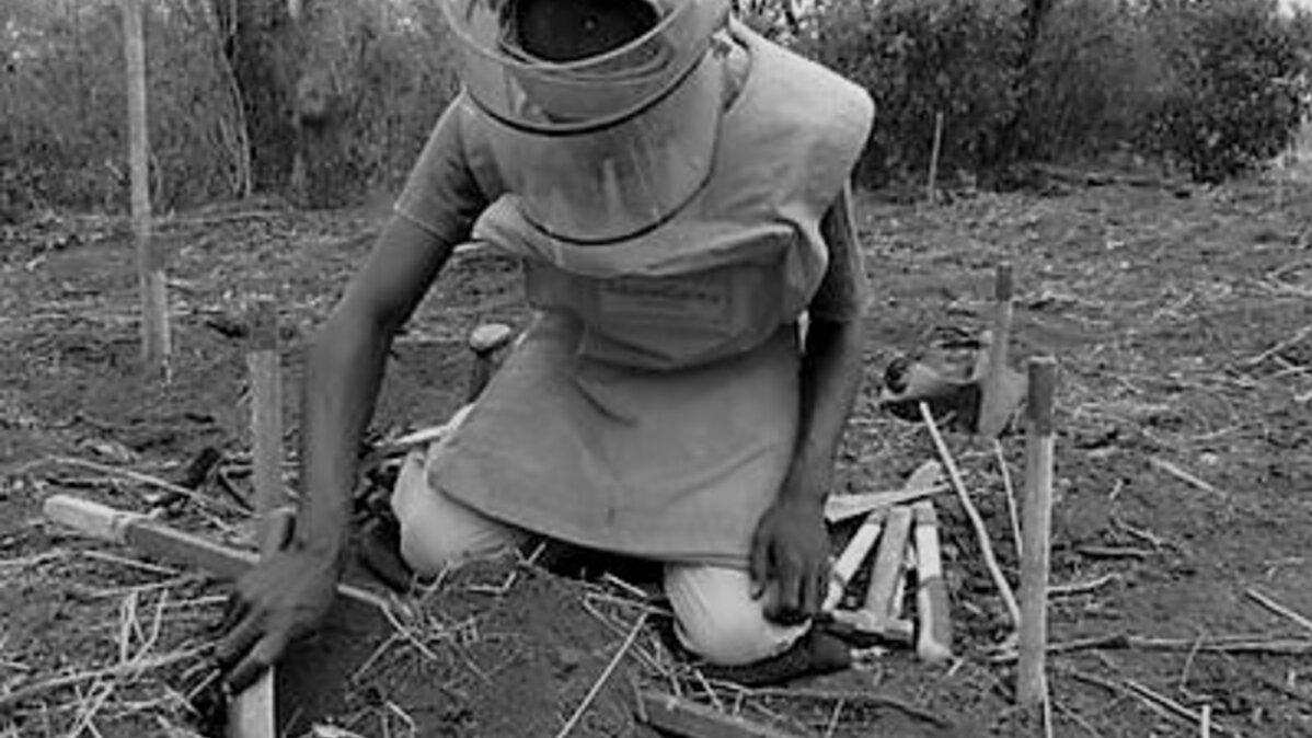 Black and white photo of an UNMAS demining an area.