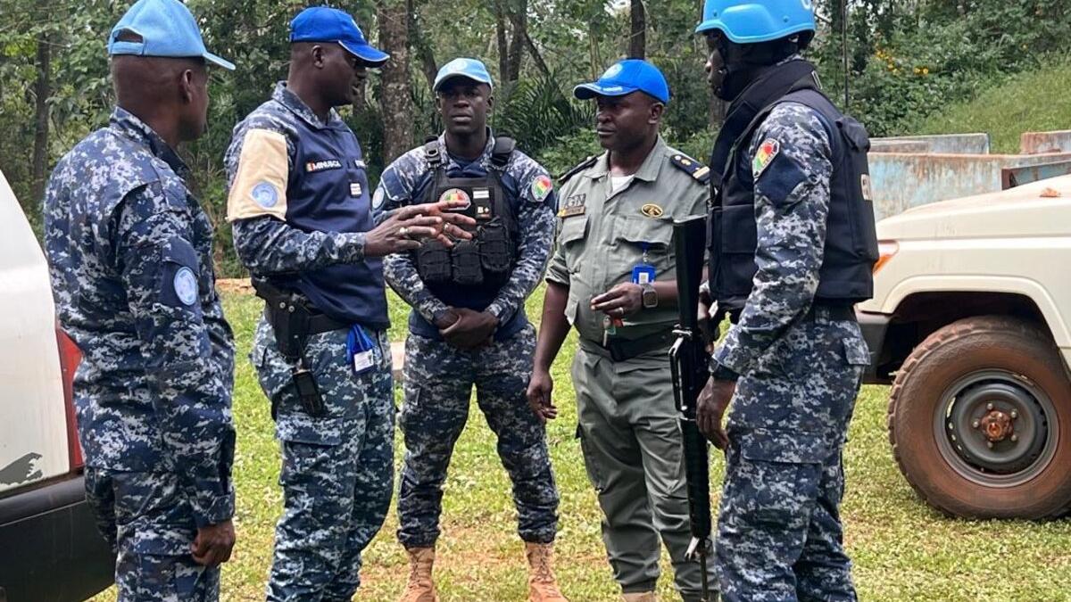 Un groupe de casques bleus discute à l'extérieur.
