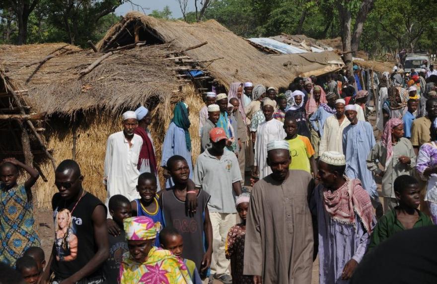 A wide view angle of a crowd of people with traditional houses on the left